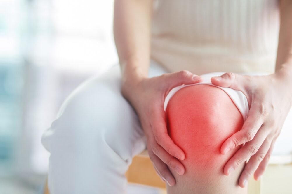 woman experiencing pain in her knee due to osteoarthritis