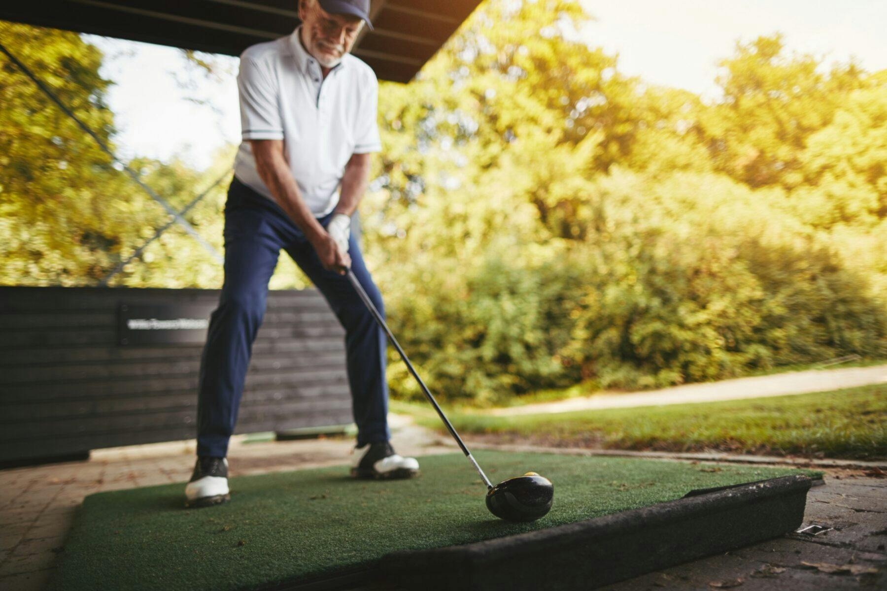 senior man practicing his golf swing