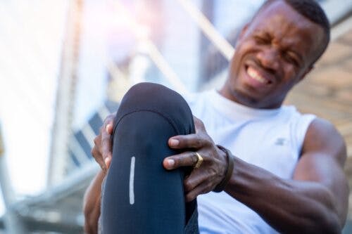 African American runner with knee pain injury