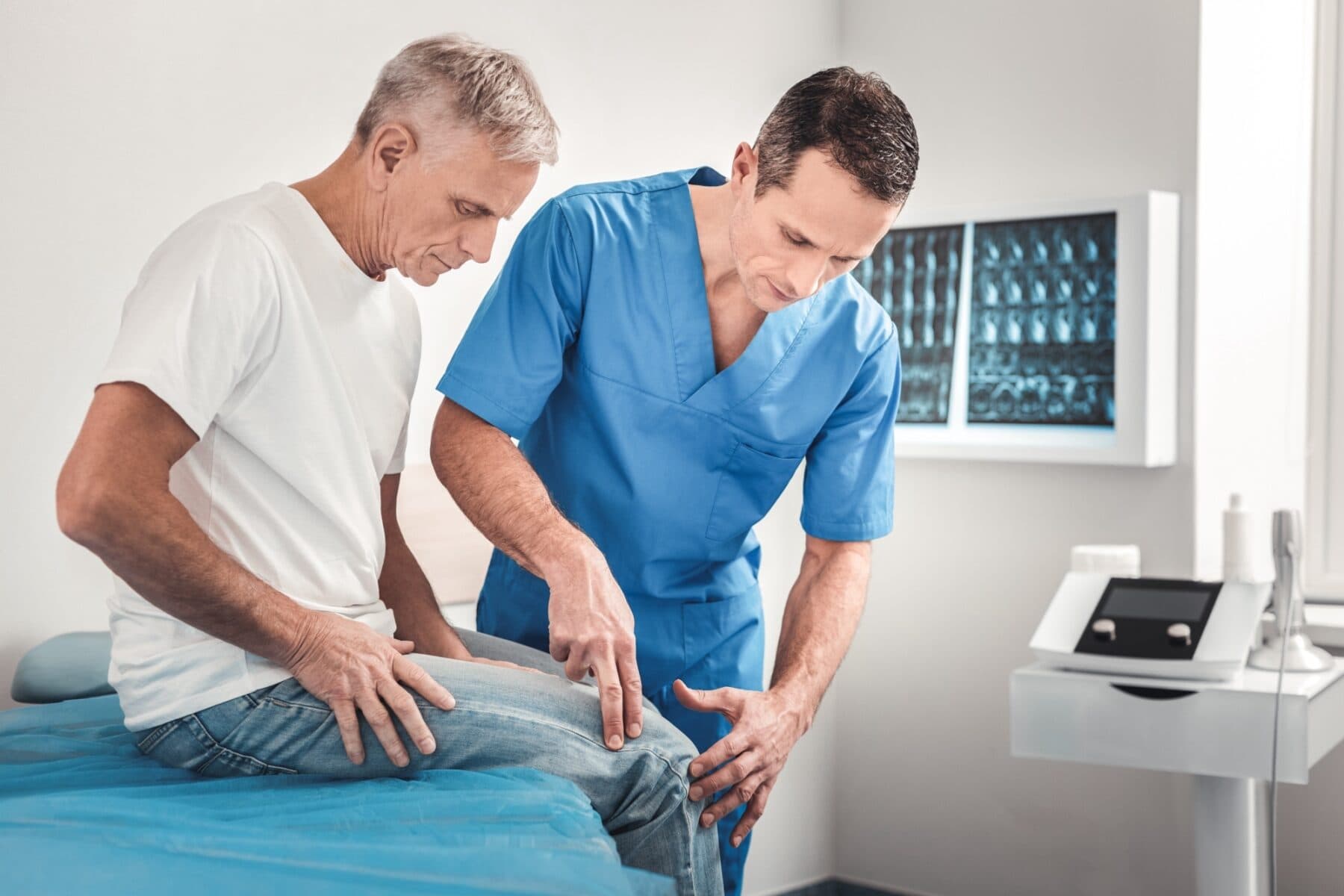 clinician in blue uniform examining a knee