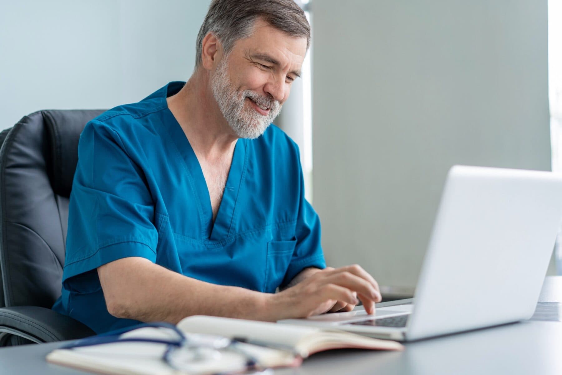 senior male doctor using a laptop