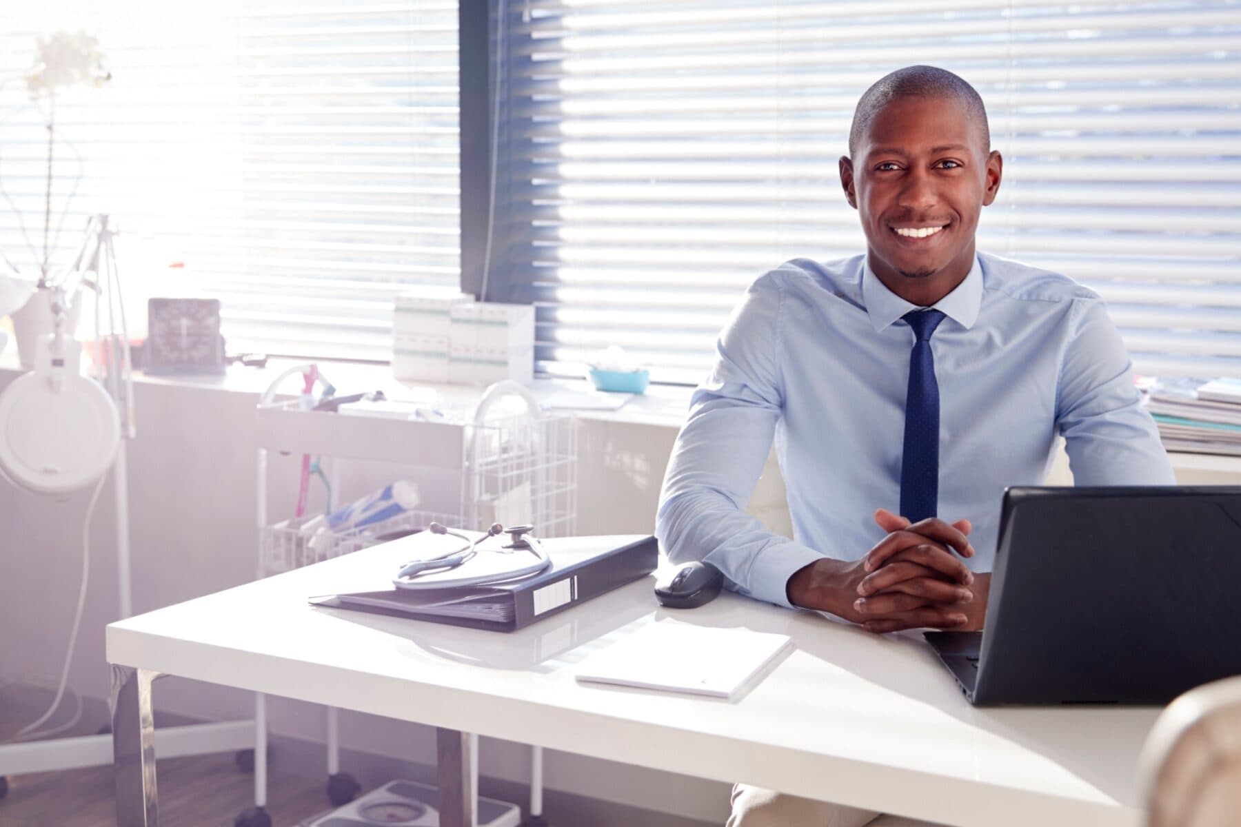 smiling male clinician in his office